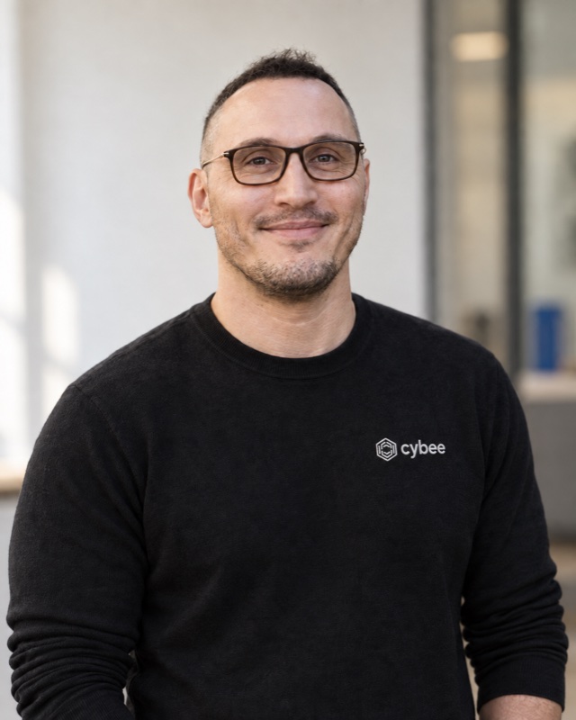 Porträt von Kristian Kabashi in einem schwarzen cybee-Pullover.